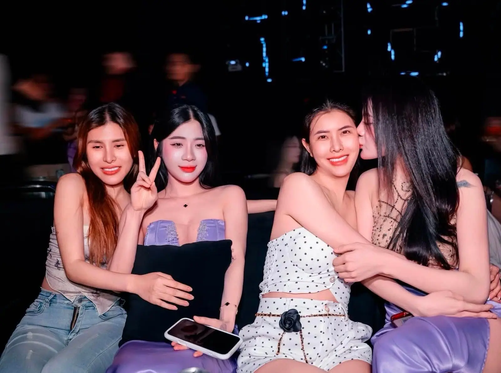 Nhóm bạn nữ cười rạng rỡ trên sofa trong không gian tối của Paradise Club