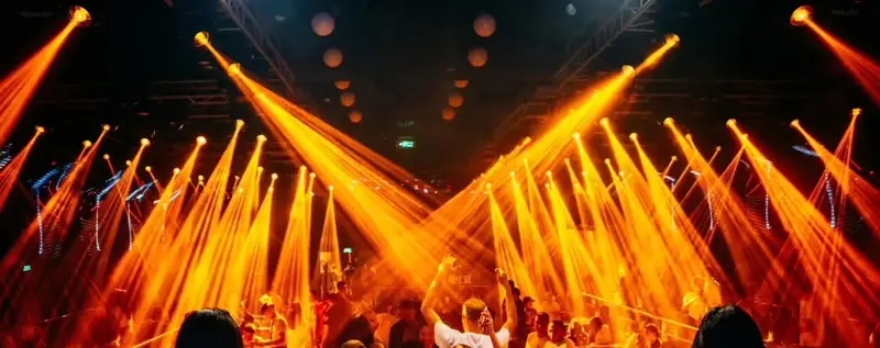 Tia đèn moving head cam vàng toả hình quạt trên trần Paradise Club